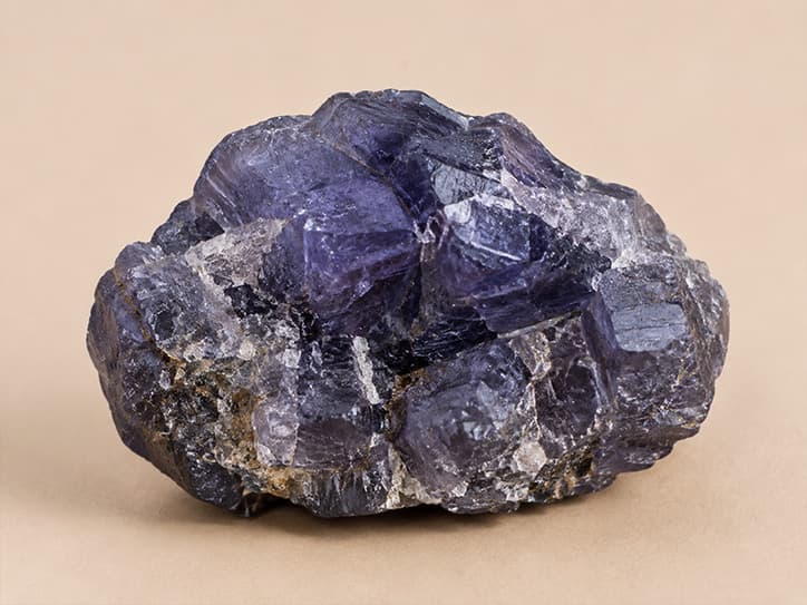 Voorbeeldfoto van ruwe ioliet met diep violetblauwe kristalvlakken