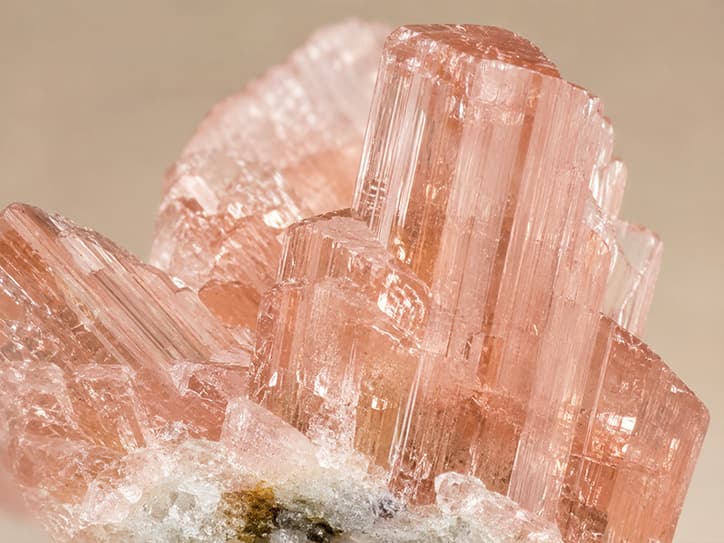 Detailfoto van morganietkristallen met verticale strepen en roze glans