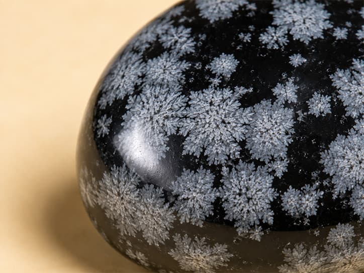 Detailfoto van sneeuwvlokobsidiaan met witte kristalvlokken