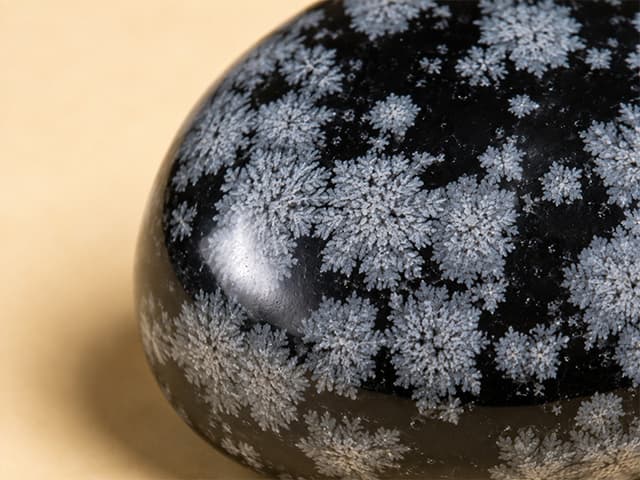 Detailfoto van sneeuwvlokobsidiaan met witte kristalvlokken
